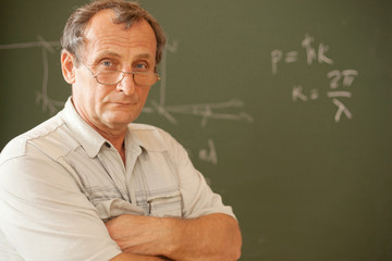 Scientist pose on background of blackboard
