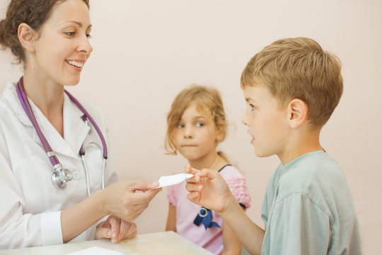 Brother and sister in doctor, doctor gives recipe boy