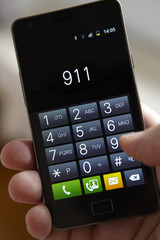 Fototapeta na wymiar Hand Dialling 911 On Mobile Phone