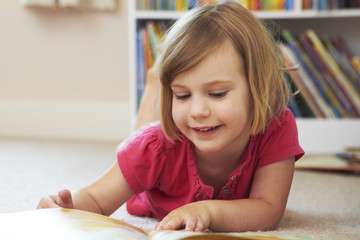Young Girl Reading Book In Bedroom