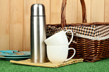 metal thermos with cups, plates and basket