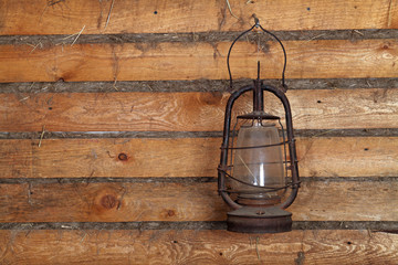 The old kerosene lamp hanging on the wall of a wooden house