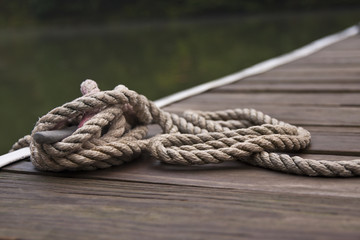 A thick rope tied into a sailor's knot by the harbor