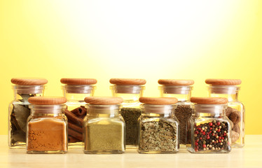 powder spices in glass jars on yellow bavkground