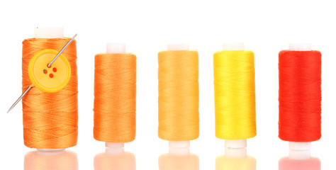 Many yellow bobbin with needle and buttons isolated on white