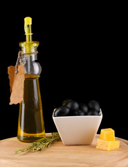 Black olives in white bowl with rosemary,olive oil and cheese