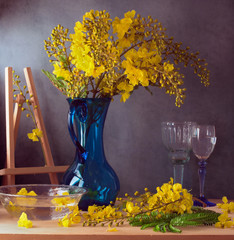 Still life with beautiful yellow flowers in blue glass jug
