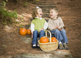 Brother and Sister Children Sitting on Wood Steps with Pumpkins