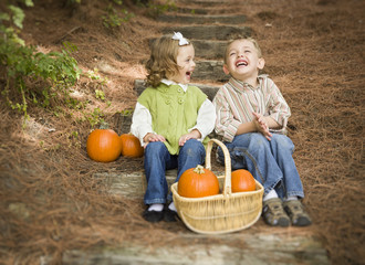 Brother and Sister Children Sitting on Wood Steps with Pumpkins