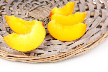 ripe peaches on wicker mat close-up.