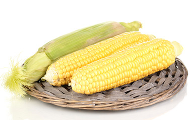 Fresh corn cobs on wicker mat isolated on white