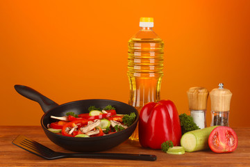 frying pan with vegetables on red background