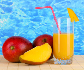 Ripe appetizing mango on woven napkin on water background