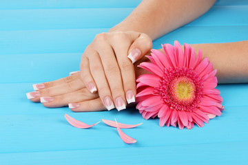 Woman hands with french manicure and flower