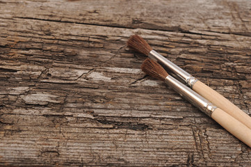 paintbrushes on very old wooden desk