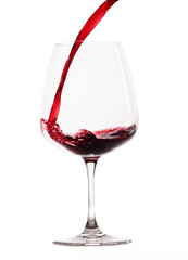Rotwein wird in ein Rotweinglas gegossen (freigestellt)