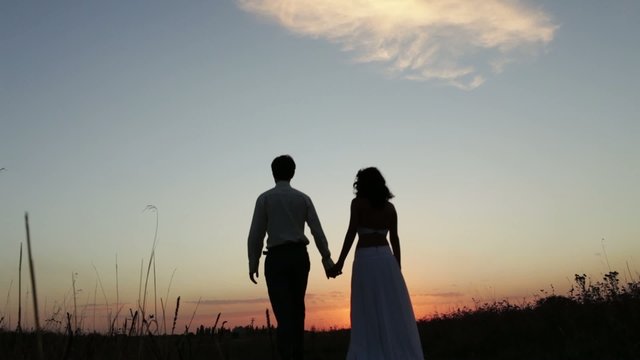 Bride and groom go into the sunset