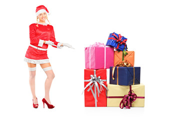 Sexy female wearing santa costume and offering presents