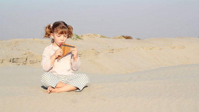 beautiful little girl play panpipe