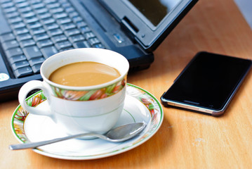Fototapeta na wymiar a cup of coffee and a laptop