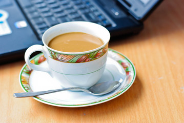 a cup of coffee and a laptop