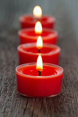 Red burning candles on a wooden rustic background