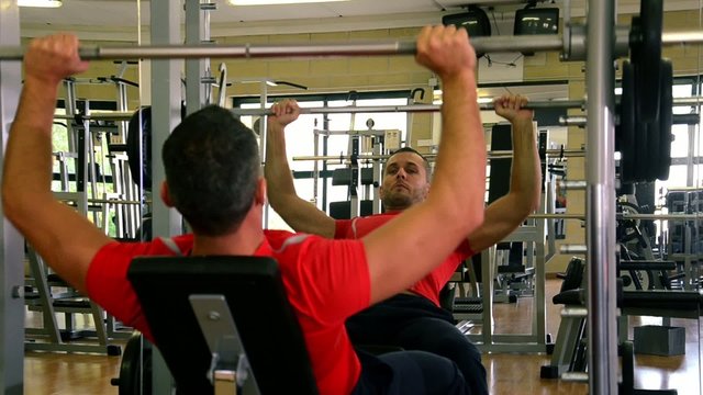 man at gym doing exercise with barbell