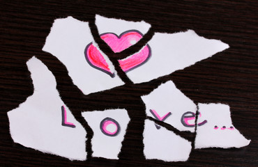 Torn paper with words Love close-up on wooden table