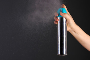 Sprayed air freshener in hand on grey background