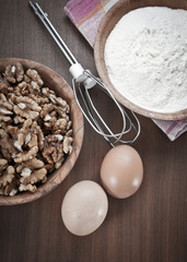 Flour,walnut and eggs on wooden background