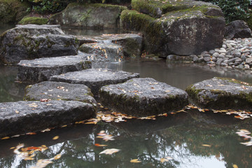 Trittsteine im Wasser in einem Garten im japanischen Stil