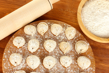 Raw Dumplings on cutting board on wooden background close-up