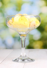 delicious ice cream on wooden table on bright background
