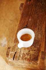 espresso coffee in thick white cup on old wooden bench