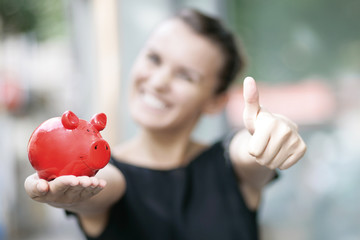 zufriedene Frau mit Sparschwein