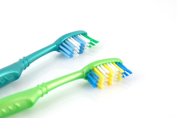 Two tooth-brushes over white
