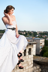 Beautiful young woman posing on the roof building.