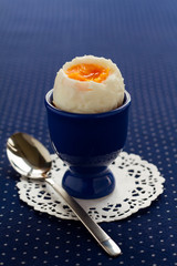 Soft-boiled egg in a dark blue egg cup