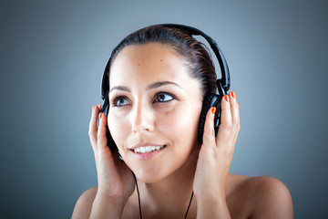 Image of beautiful young woman listening to music with headphone