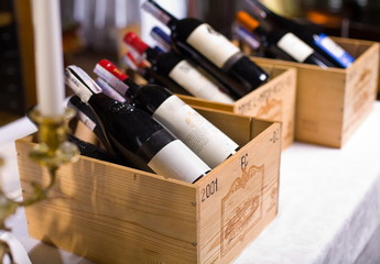 Wine bottles in wooden boxes. - obrazy, fototapety, plakaty
