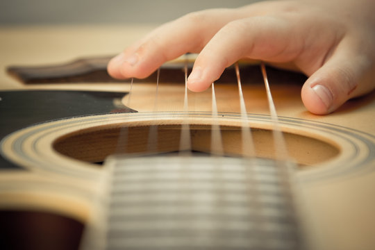 Macro shot down the fretboard of acoustic guitar with shallow de