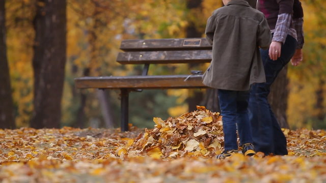 Family gathering maple leaves in an autumn park