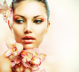 Beautiful Girl With Orchid Flowers. Beauty Woman Face