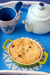 Crumble topping cake with tea pot and a cup served on the tray