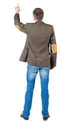 Naklejka premium Back view of pointing business man in jacket
