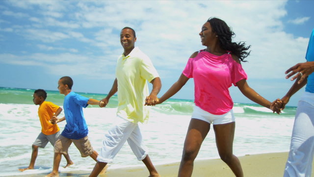 African American family laughing and running together in surfs