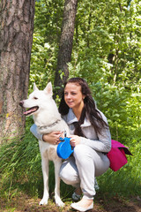 The young woman with a white dog on the nature