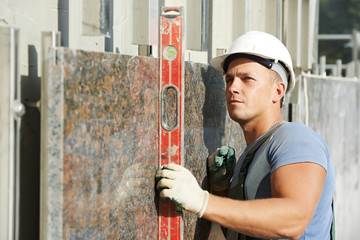 builder facade plasterer worker with level