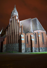 Fasada i wieża gotyckiego kościoła nocą w Poznaniu