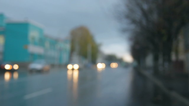 defocused cars moving on street at rain
